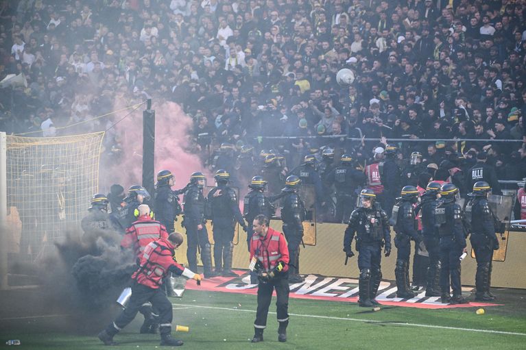 Des supporters nantais regagnent leur tribune sous haute surveillance des forces de l'ordre