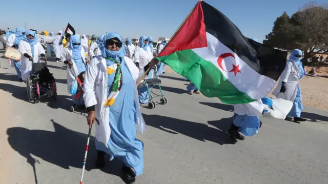 Une manifestante âgée brandit un drapeau du Sahara occidental lors d'une protestation