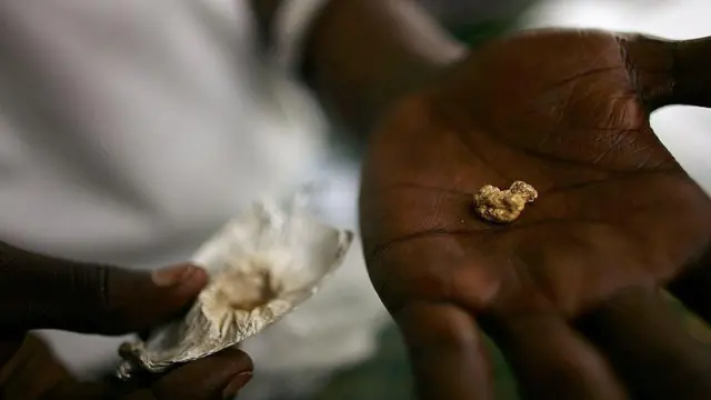 Un individu tient une pépite d'or dans sa paume