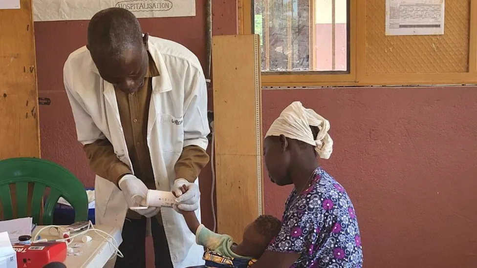 Médecin examine un enfant atteint de paludisme au Nord-Kivu
