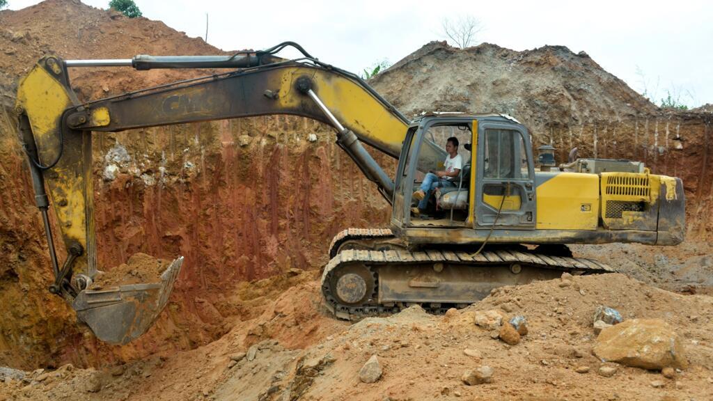 Un employé chinois d'une société minière travaille sur un bulldozer dans une mine d'or près de Betare Oya, Cameroun